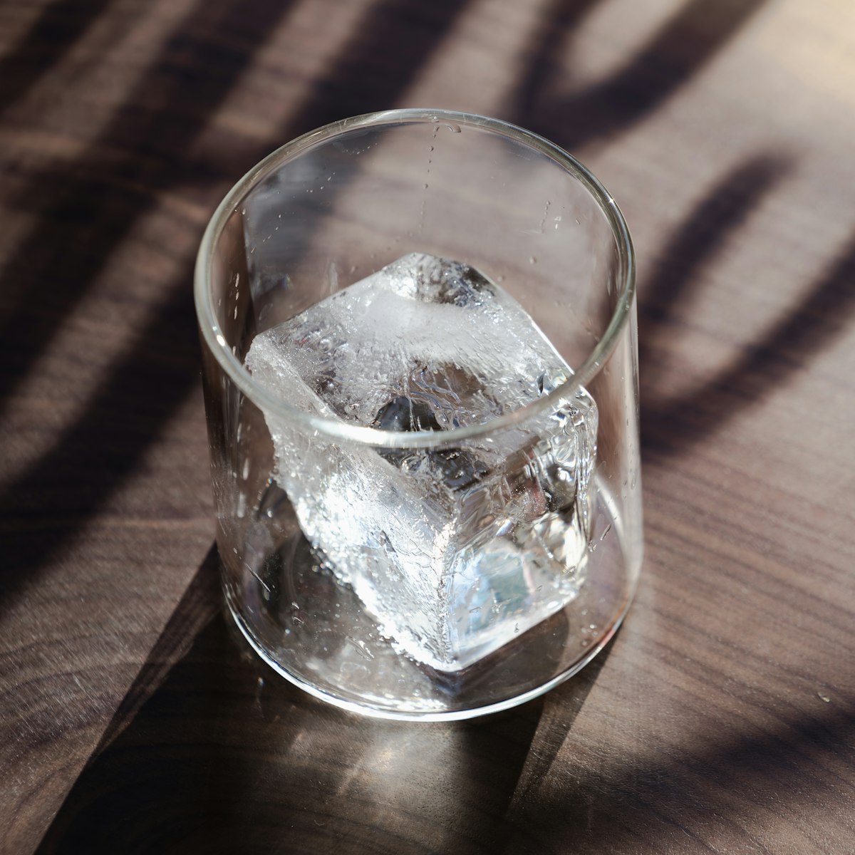 best ice makers for home - clear ice cubes in a glass on a wooden table